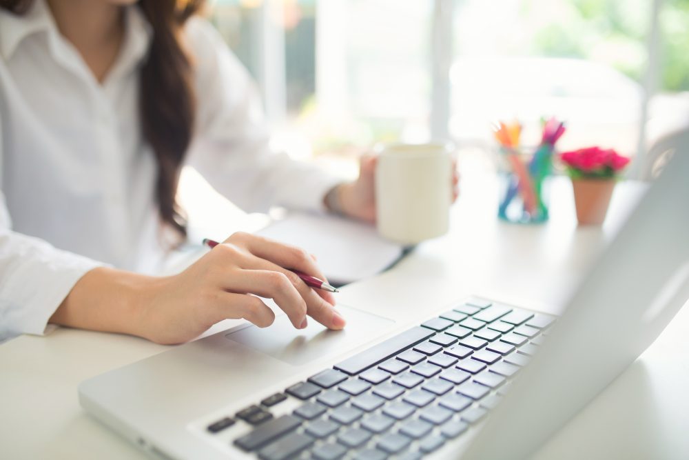 closeup of female hands busy using on a laptop